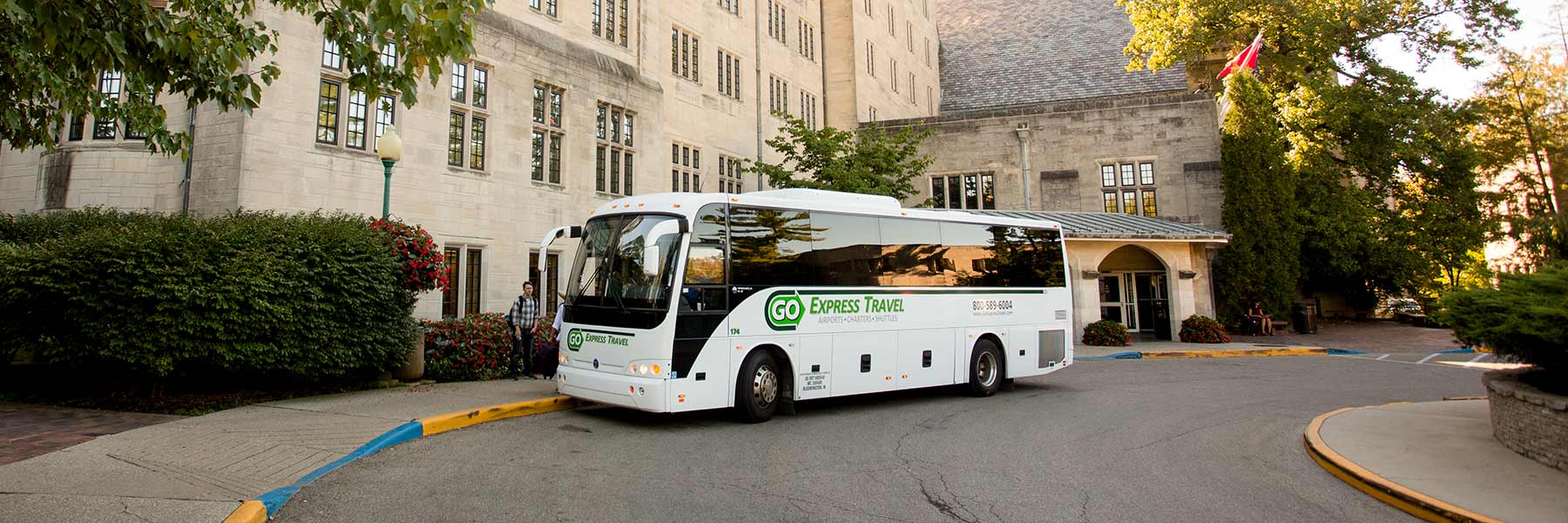 A Go Express Travel bus parked in the circle drive of Memorial Union