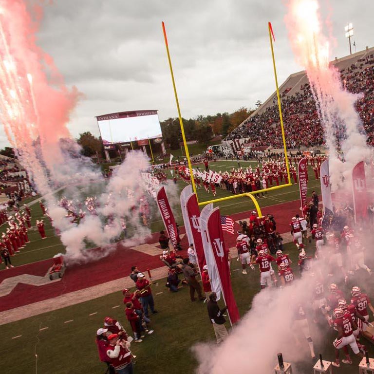 The IU football team runs on to the field at the start of a game.